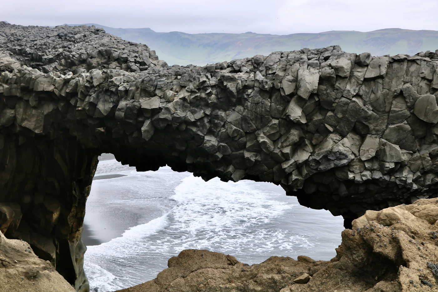 The rock arch at Dyrhólaey with surf breaking through it