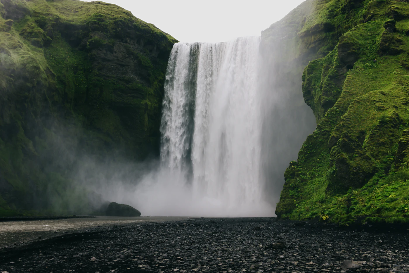 Skógafoss between green cliffs
