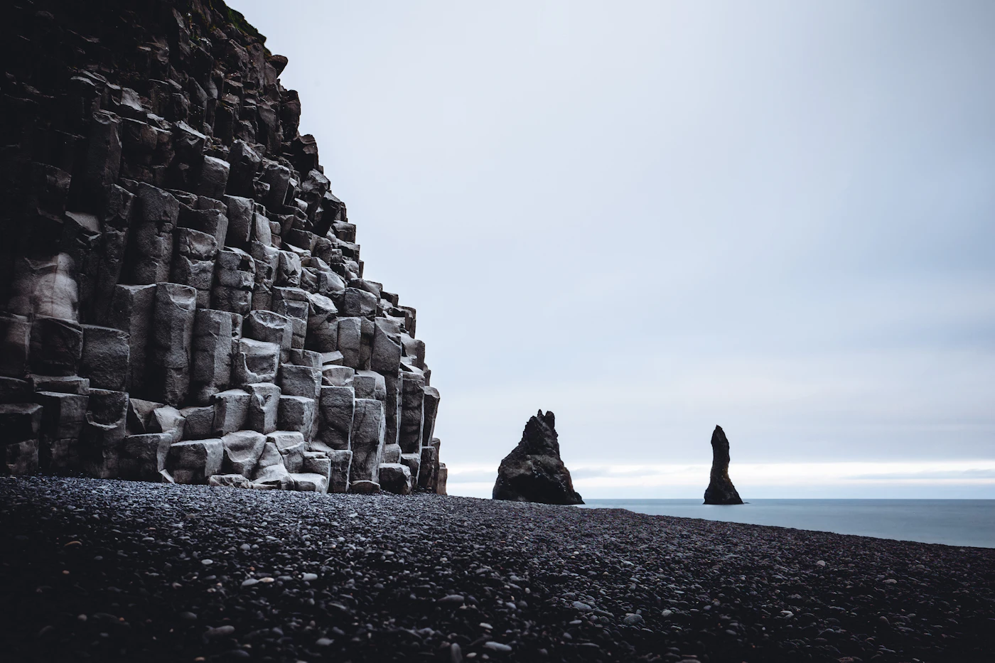 Basalt columns and the Reynisdrangar sea stacks on a black beach