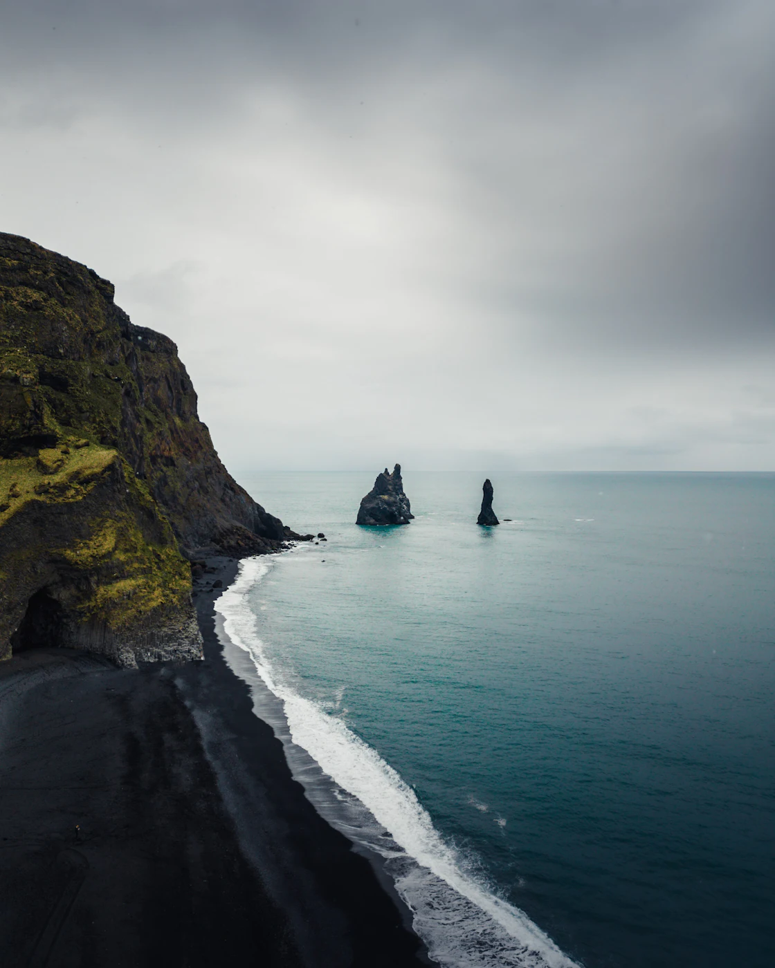 Reynisdrangar sea stacks beyond a green headland