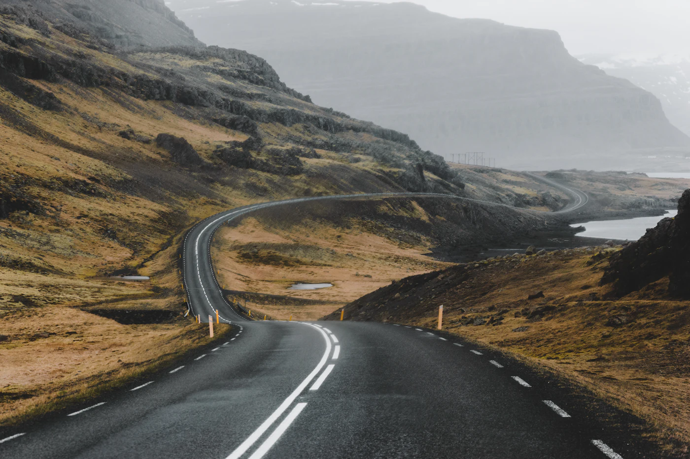 A road curving around a misty headland