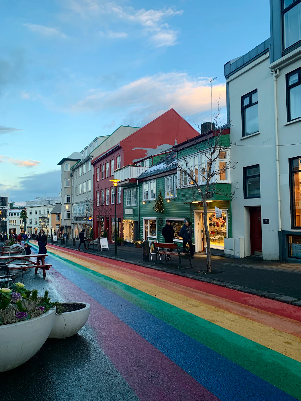 Rainbow stripes painted along a street of colourful shops