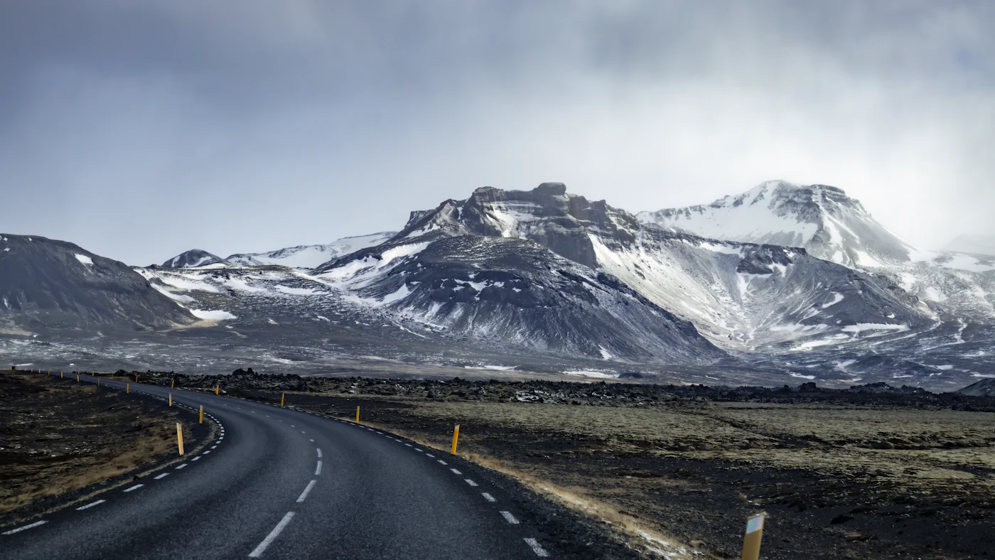 A snow-streaked mountain beside a quiet road
